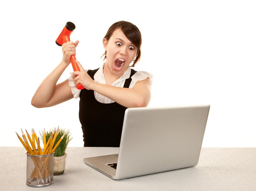 woman with hammer about to smash computer